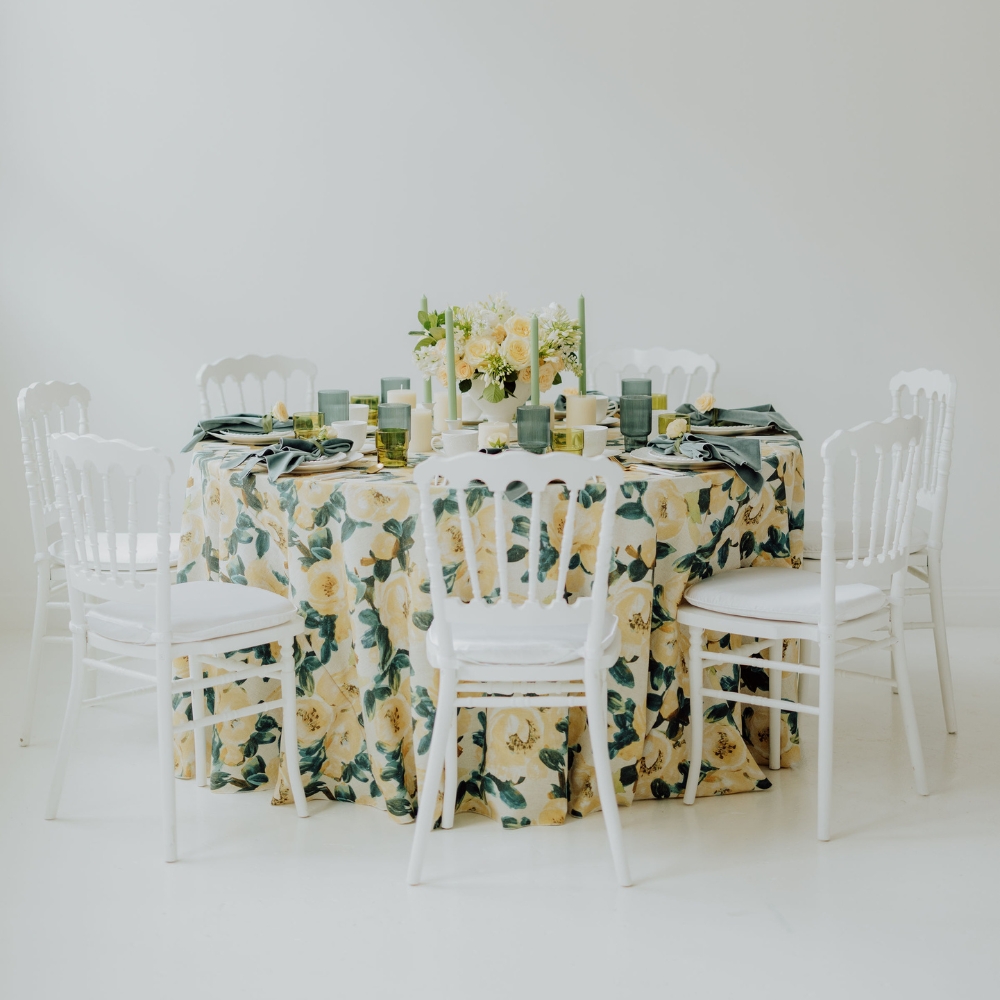 A table with Ophelia Lemon Table Linen and white chairs