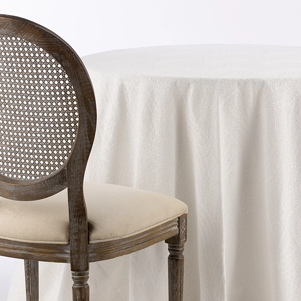 A chair next to the table with Caterina White Embroidered fabric