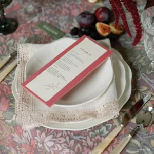 A table setting with plates, silverware, and a Country Lace Napkin available for event linen rental.