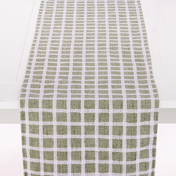 A Patchwork Moss table runner rental on a white surface.