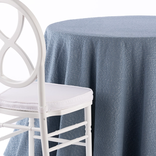 A chair next to the table with Boucle Powder Blue linen