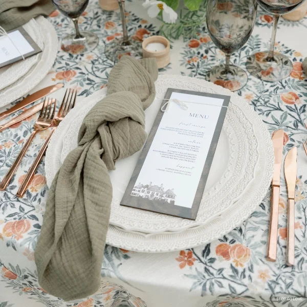 An elegant table setting with a Callie Olive Napkin and silverware available for event linen rental.