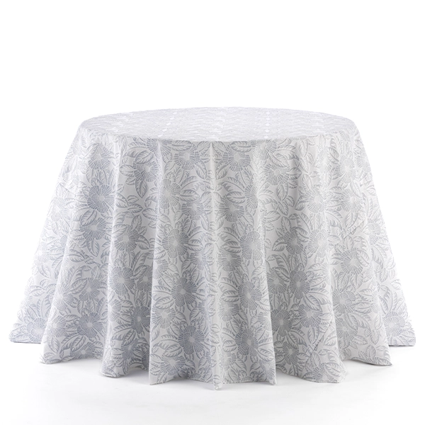 A round white Gracie French Grey table with a floral pattern on it available for event linen rental.