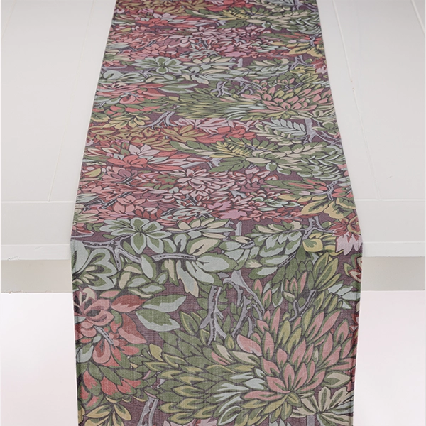 A Mariposa Garden Table Runner with a floral pattern available for event linen rental.