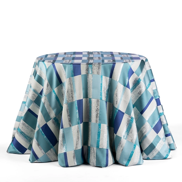 A round table with a Metropolitan Aqua checkered cloth available for event linen rental.