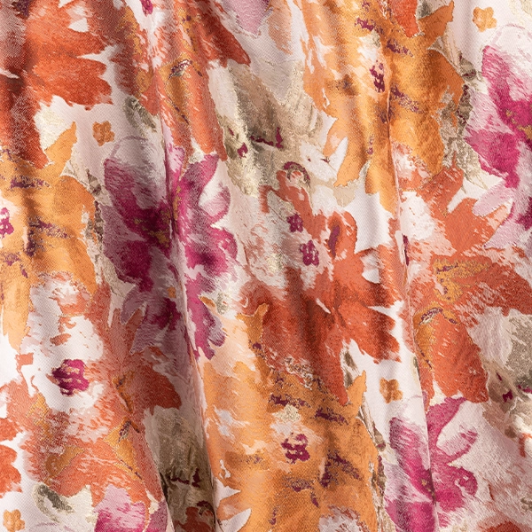 A close up of a Penelope Pomegranate fabric with cueva de las manos in the background. Table linen rental.