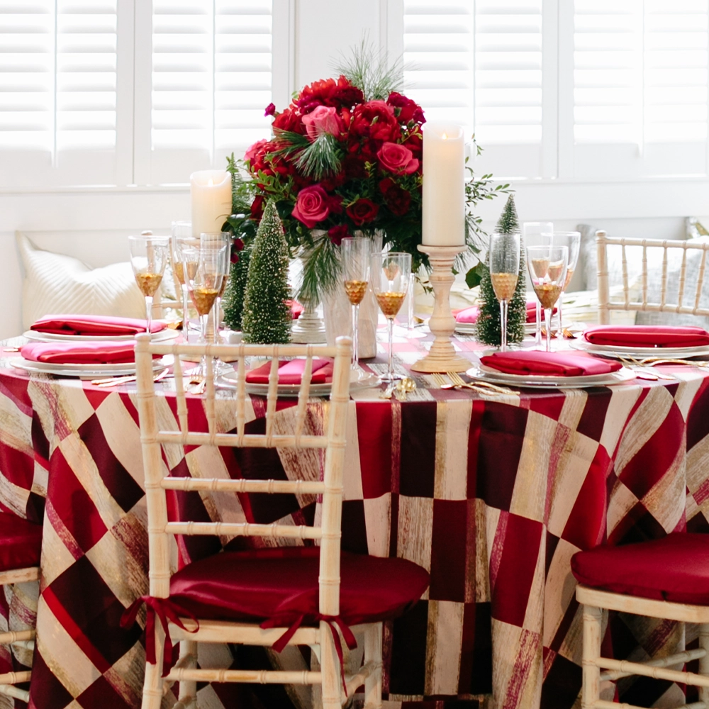 An event table with a red and white checkered tablecloth and matching chairs.