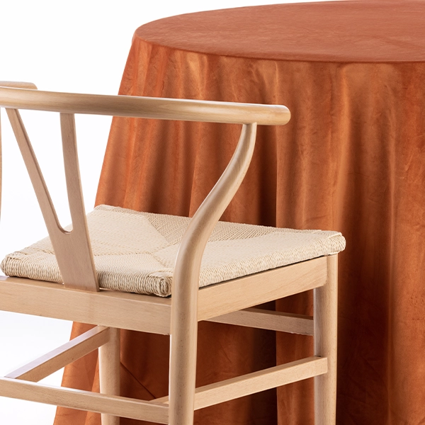 A Velvet Rust chair placed next to a table for an event.