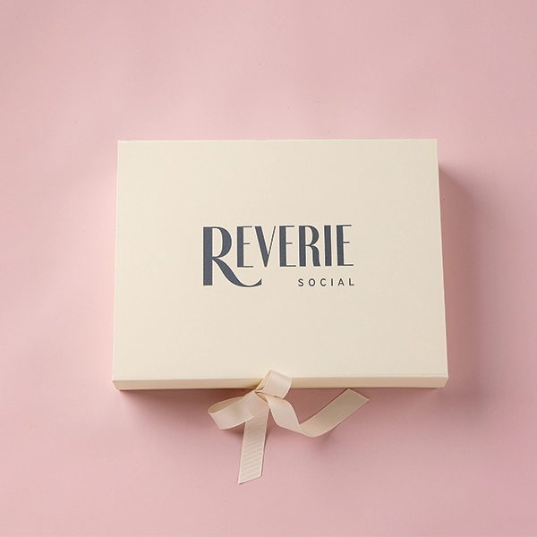 A Core Collection Swatch Box with a pink ribbon, available for event linen rental.