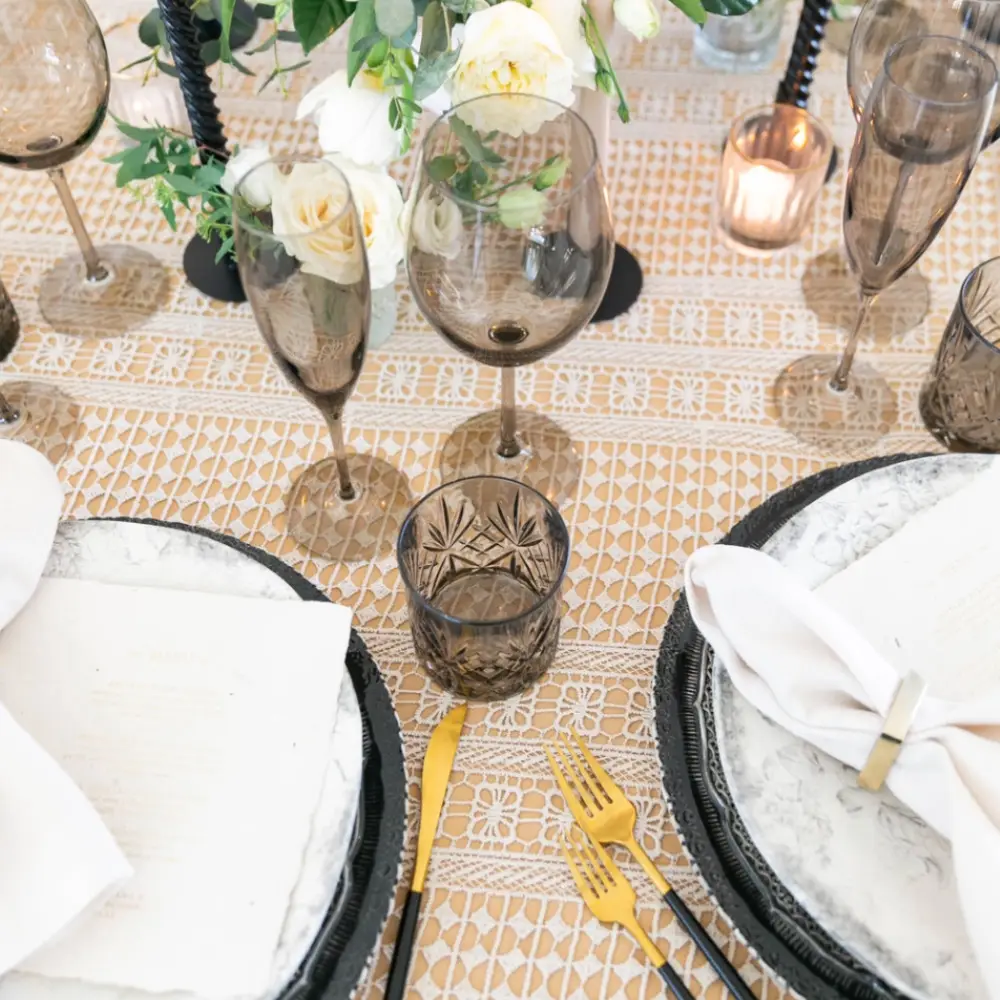 A table with glasses and plates available for event linen rental.