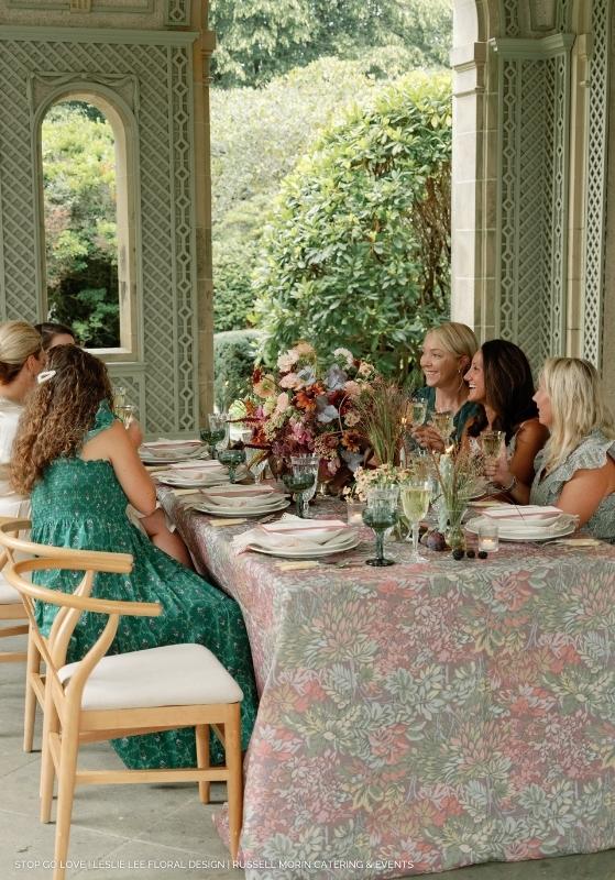 A group of women sitting at a table adorned with elegant table linens.