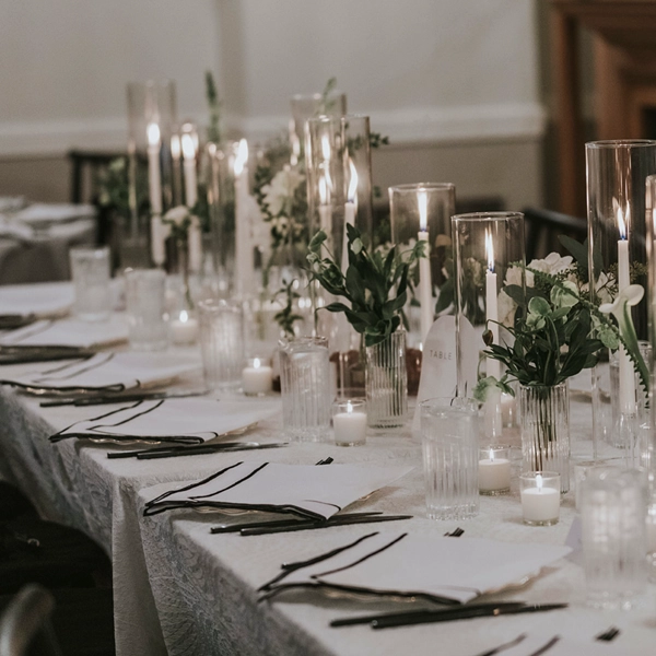 An elegant table adorned with candles and flowers, perfect for any event or wedding. Simplify your planning by opting for our convenient Lessing Black Stitch Napkin rental services.