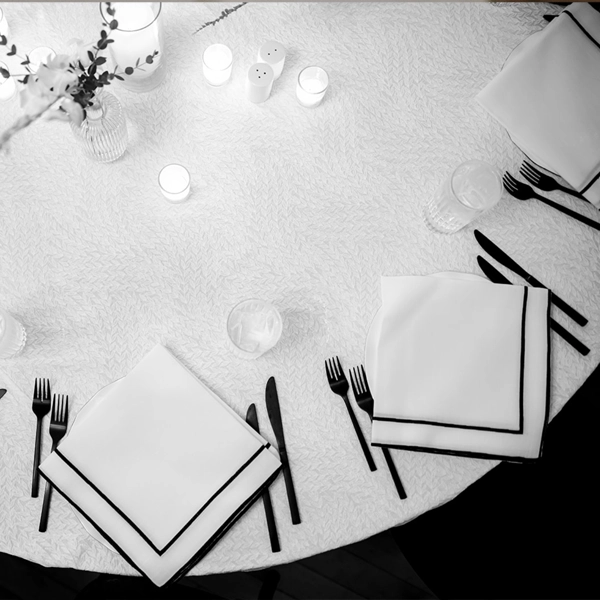 An event table rental with cutlery and Lessing Black Stitch Napkins, complete with accompanying table linen rental.