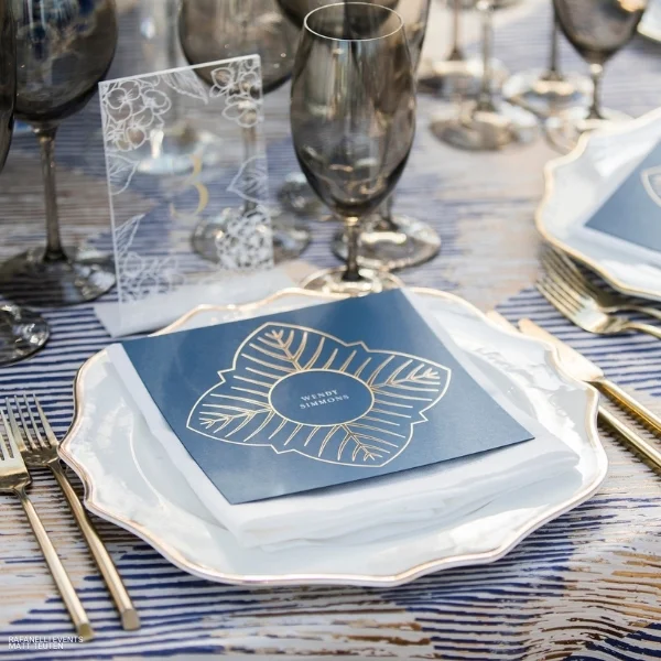 A Barcode Navy table with plates and glasses available for event linen rental.