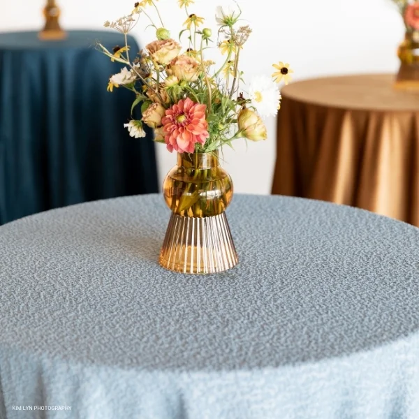 A Boucle Powder Blue with flowers on a rental table.
