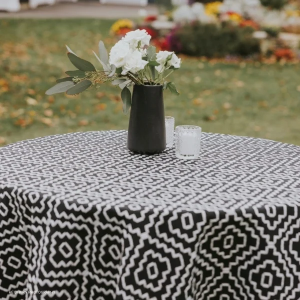 An elegantly adorned Campbell Black table, featuring a vase with stunning flowers and gentle candlelight.