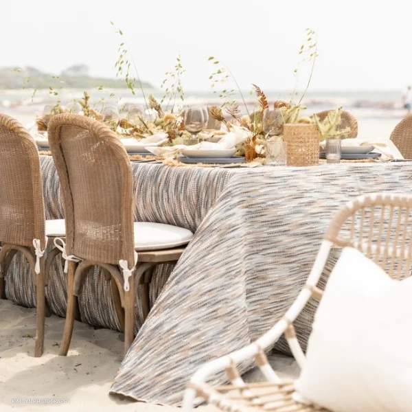 An event table set up on a beach with Canyon Agate table linen rental.