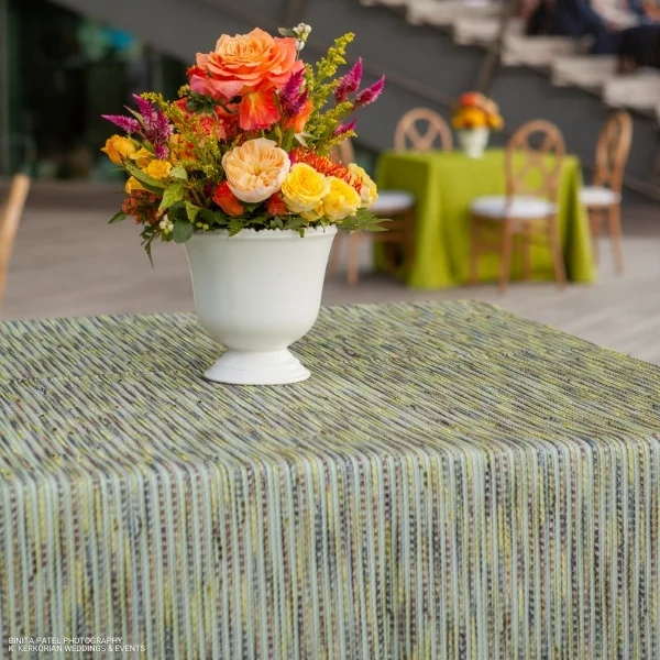 A vase of Canyon Spring flowers on a table with event linen rental.
