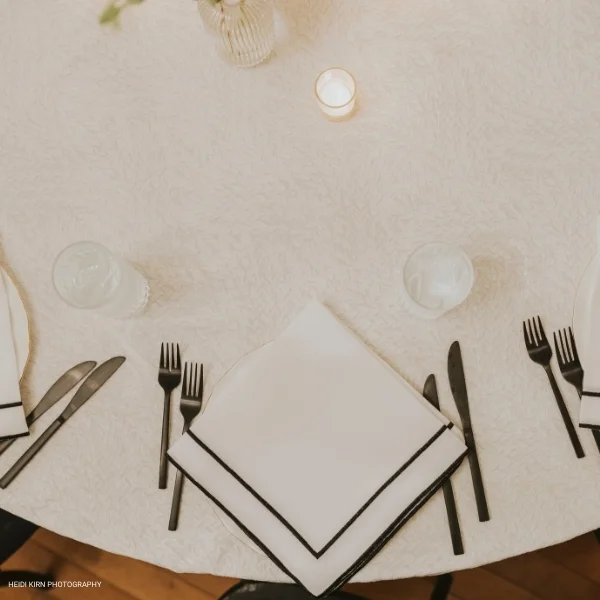 A table with a Caterina White tablecloth available for table linen rental.