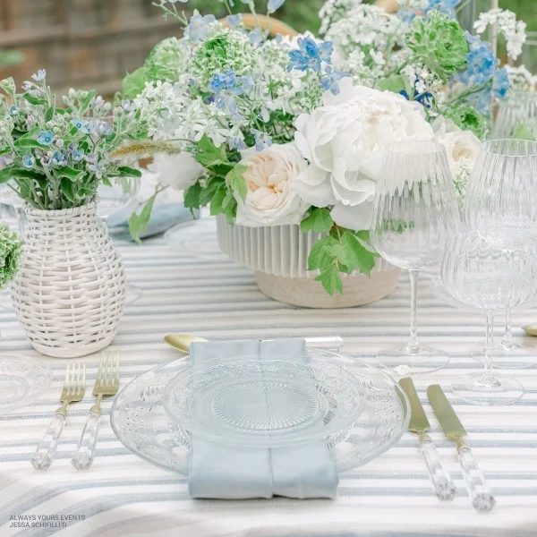 Rent a stunning Velvet Ocean Napkin for your next event, featuring a beautiful arrangement of flowers and elegant glasses.