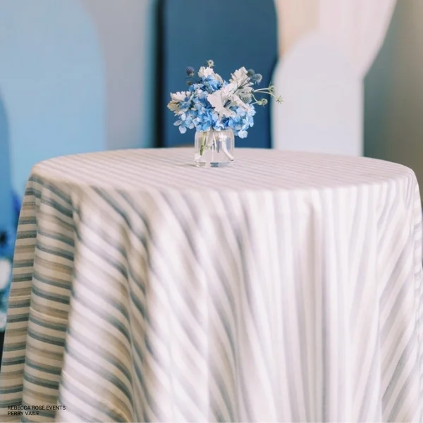 A small vase of flowers on a table adorned with Davey Coastline Blue rental.