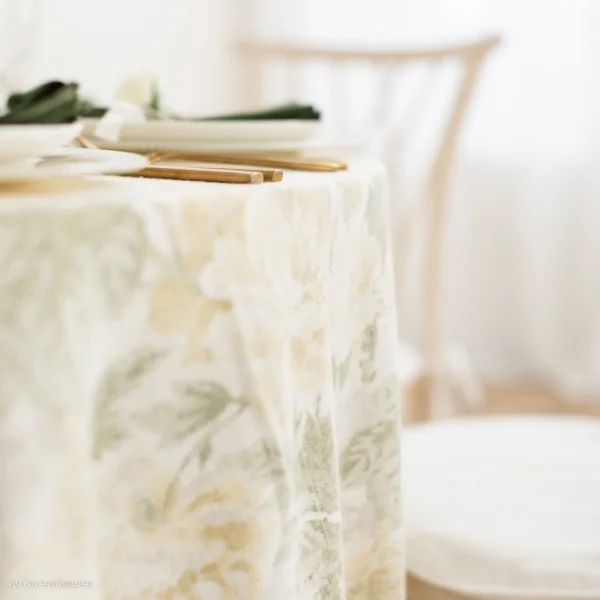 A table with a Garden Rose Lemon pattern tablecloth available for event linen rental.