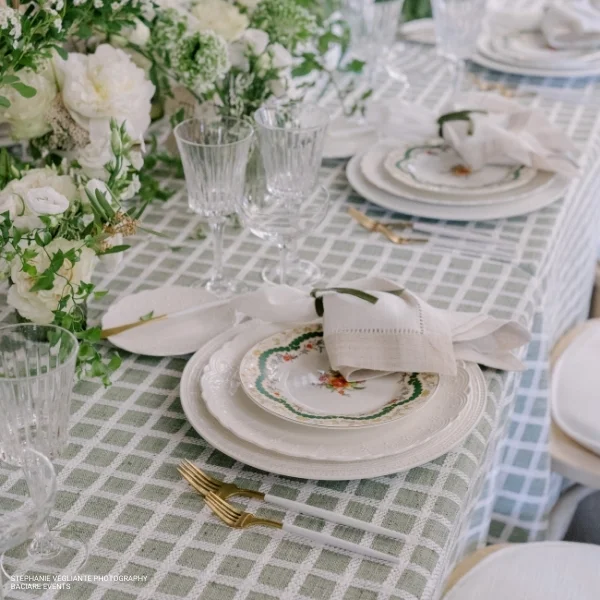 An event table with Patchwork Moss plates and glasses available for table linen rental.