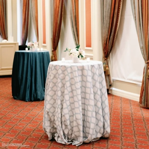 Two tables with Lexington Seafoam tablecloths available for event linen rental.
