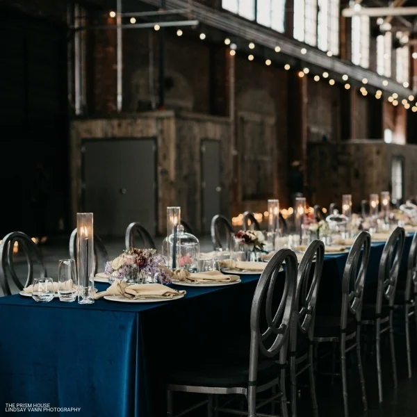 A long table set for a dinner party with Montana Suede Navy event linen rental.