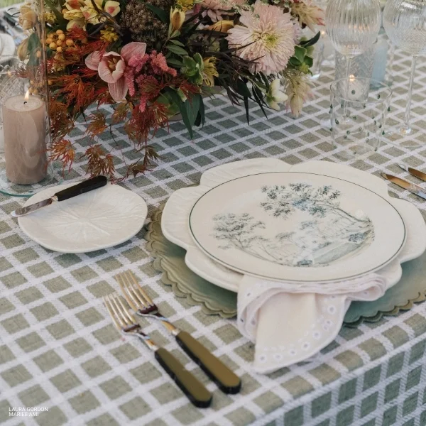 An event table with Sadie Scalloped Cream Napkin and silverware available for rental.