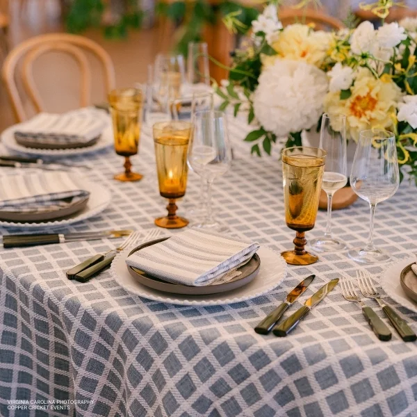 A elegantly dressed Patchwork Sea Breeze set for a dinner party with table linen rental.