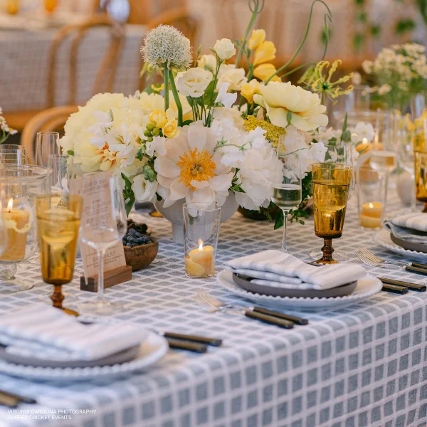 A table set with flowers and glasses available for Patchwork Sea Breeze linen rental.