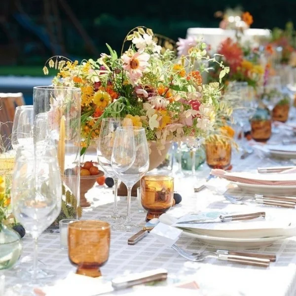An elegant Patchwork Zinc adorned with beautiful flowers and delicate glasses, perfect for any event or occasion.