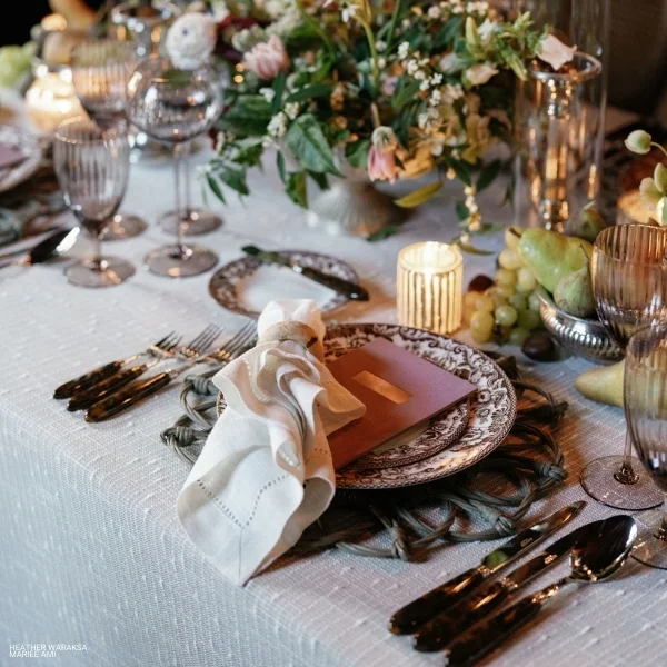A table with Riga Sand plates, cutlery, and event linen rental.