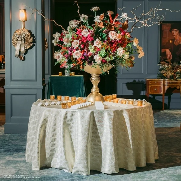 An event Stella Champagne rental displaying a table with flowers on it in a room.