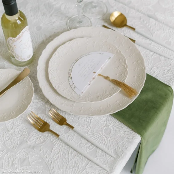 A white table setting with Velvet Evergreen Napkins available for event linen rental.
