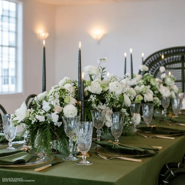 A beautiful table setting adorned with Velvet Evergreen Napkins and candles, perfect for an elegant event.