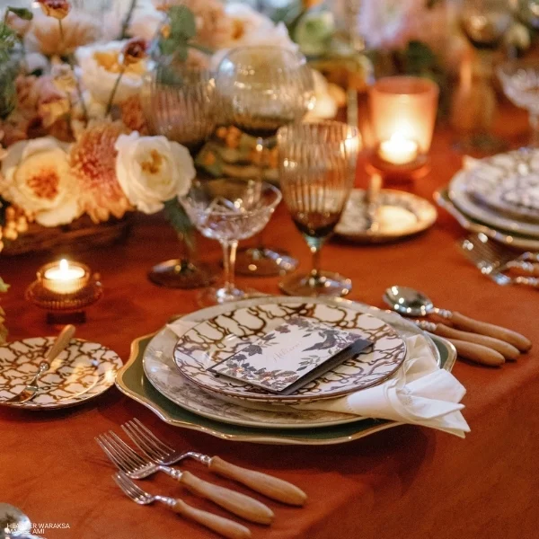 An Velvet Rust table setting with flowers and silverware, perfect for your event linen rental needs.