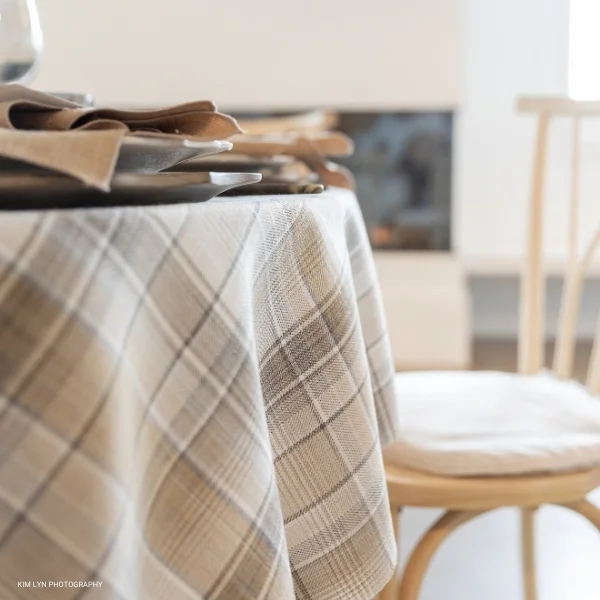 A Weston Wheat Plaid tablecloth is on a table in a dining room available for event linen rental.