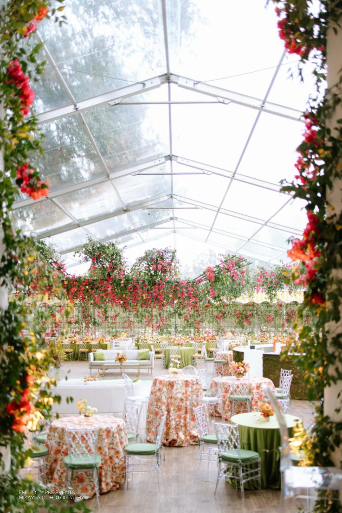 A wedding reception in a tent decorated with flowers and greenery. Our services include table linen rental.
