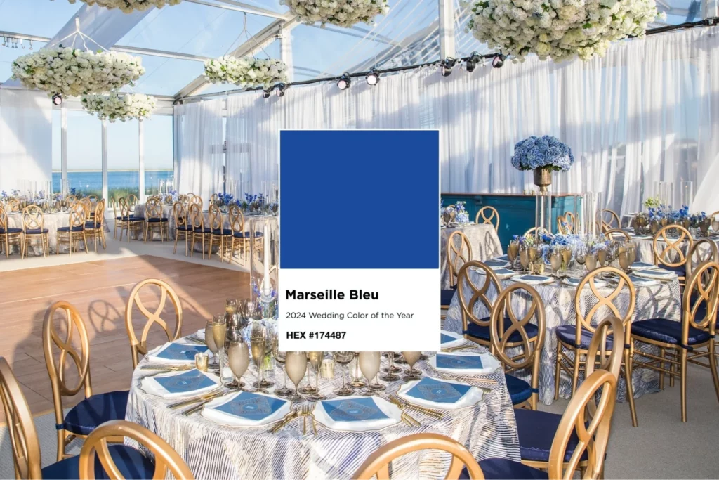 A blue and gold wedding reception with table linen rental in a tent.