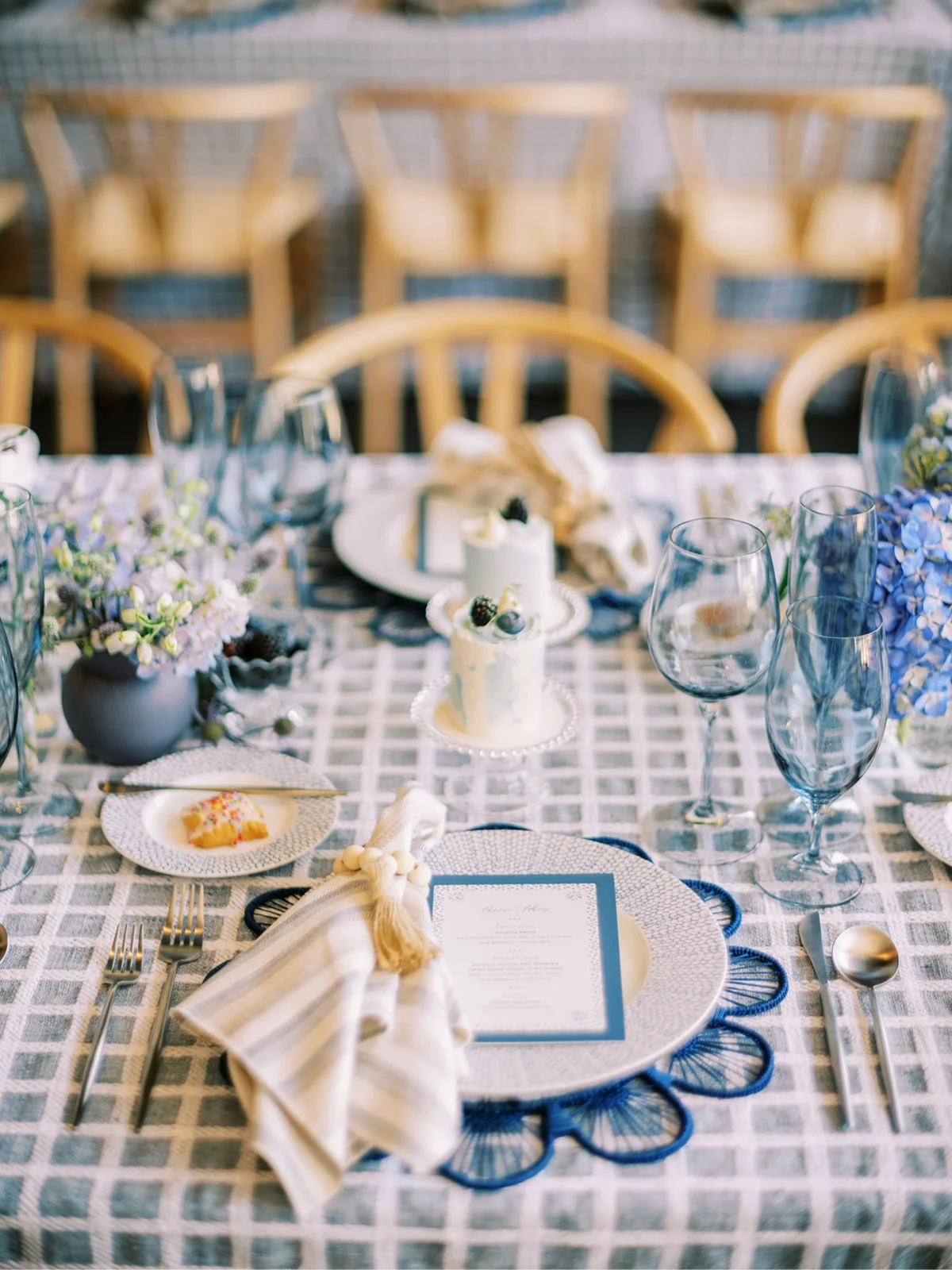 Elegant table setting with blue floral centerpiece, patterned table linens, and place cards for a wedding shower.