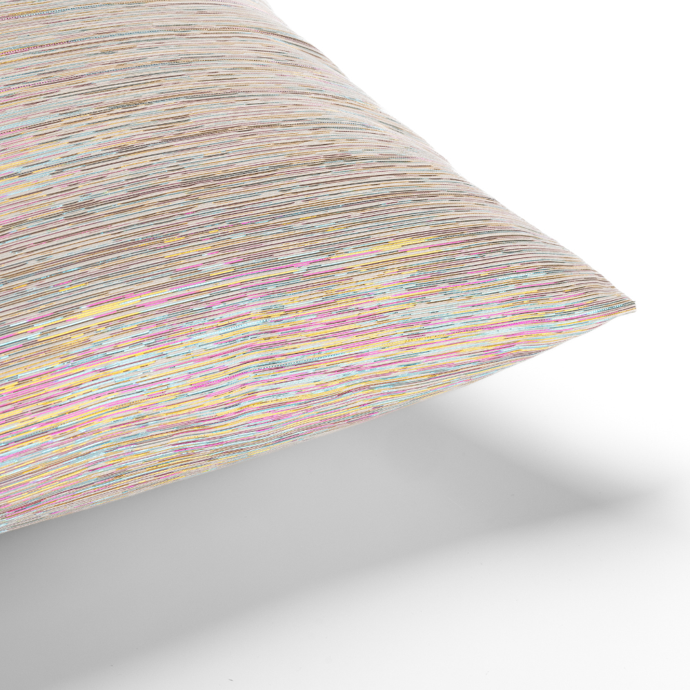 The Roxy Rainbow Metallic Pillow, with its textured fabric showcasing horizontal multicolored lines, rests on a white surface.