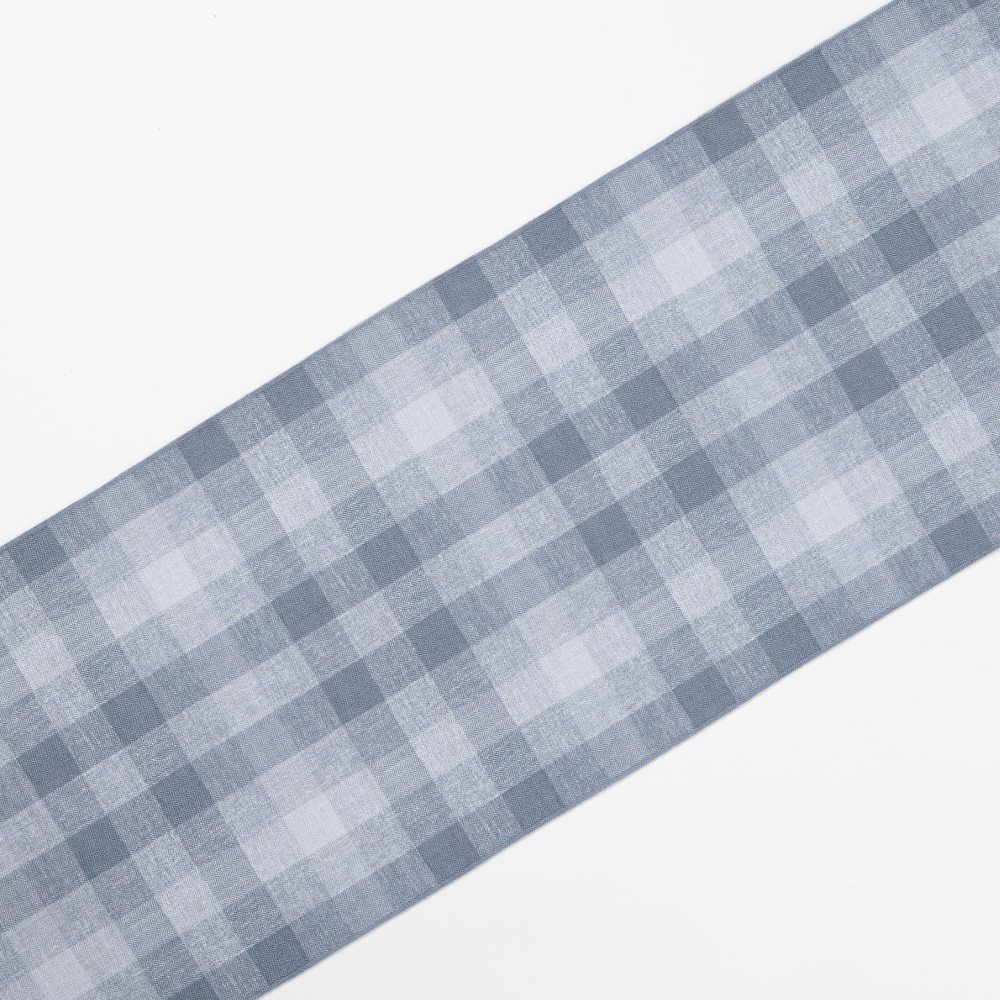 A Checkered Plaid Harbor Table Runner with a blue and white pattern is displayed diagonally on a plain white background.